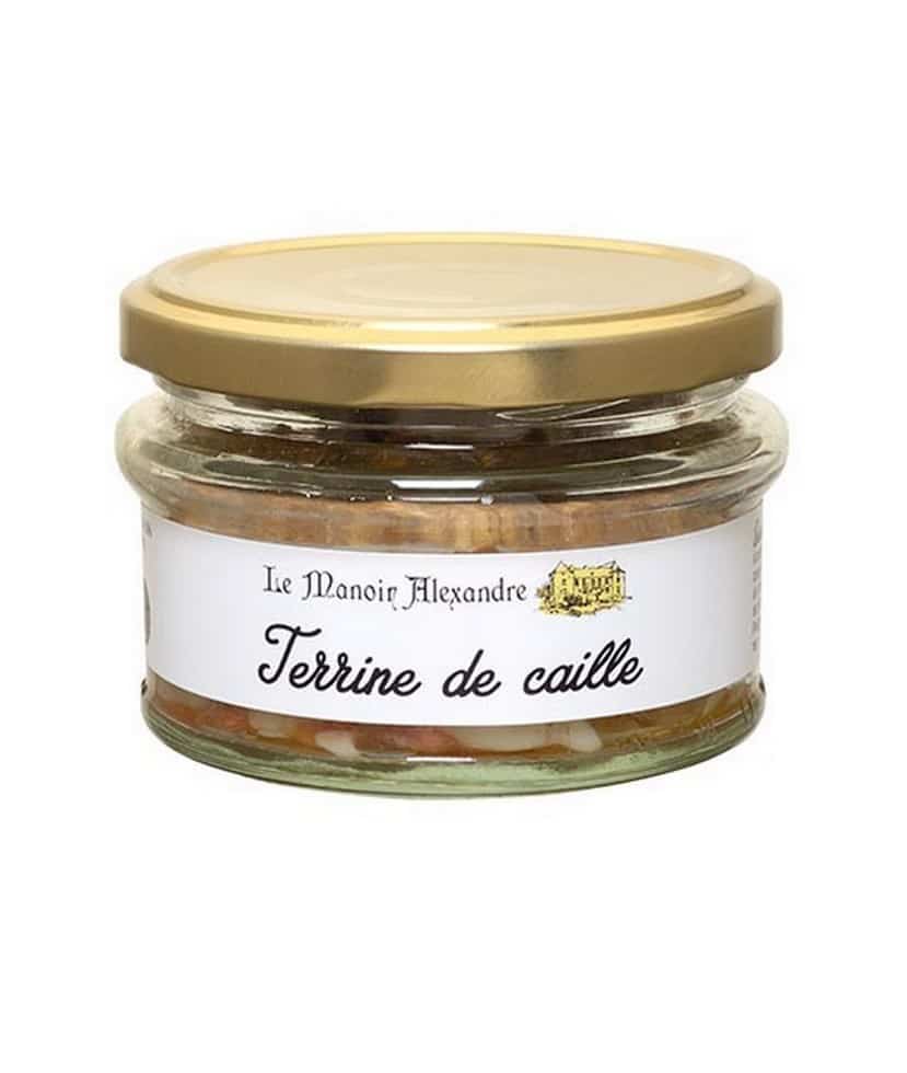 Burken med Manoir Alexandre Terrine de Caille 100g, visad med ett tunt lager av gelé och garnerad med små kryddor eller ett lagerblad.