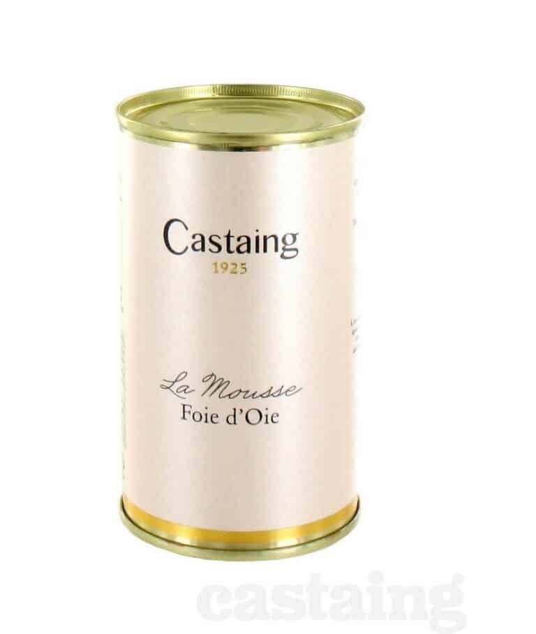 Burken med Castaing Mousse de Foie d'Oie 200g, visad med smörkniv och garnerad med örter och vinbär på en träskiva.