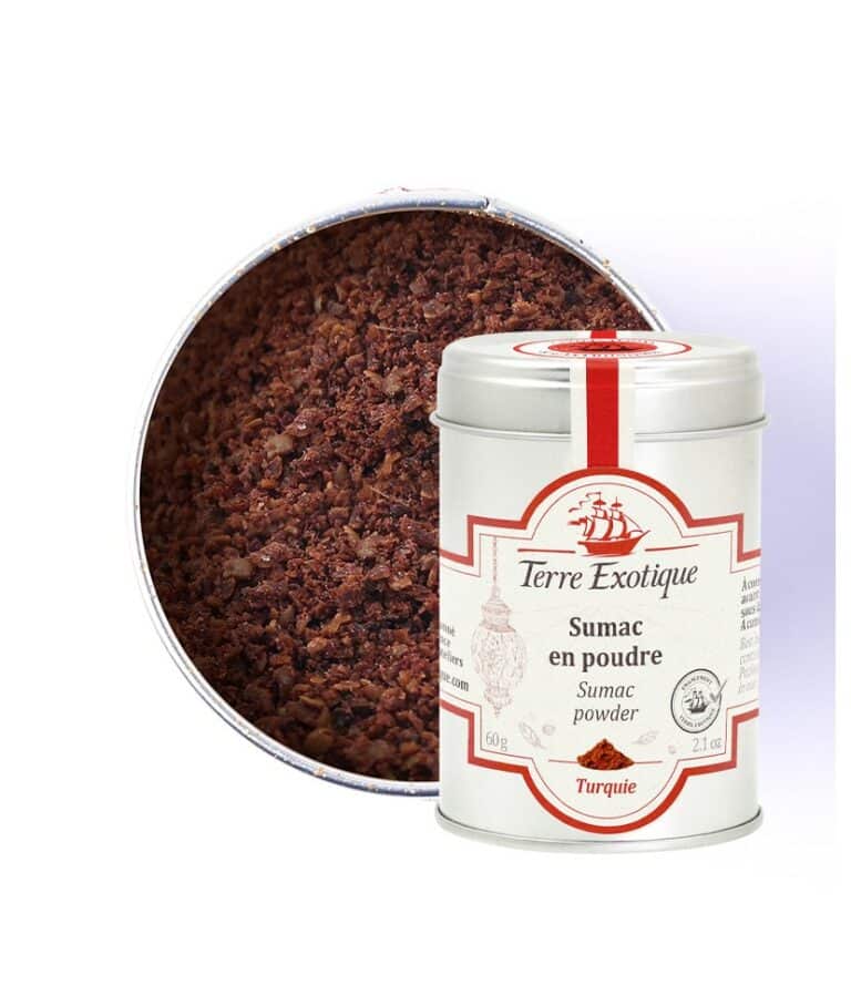 Burk med Terre Exotique Sumak (60g). Det mörkröda kryddpulvret ligger på en sked bredvid en skål med hummus, färska örter och citronklyftor, i en Mellanöstern-inspirerad gourmetmiljö.