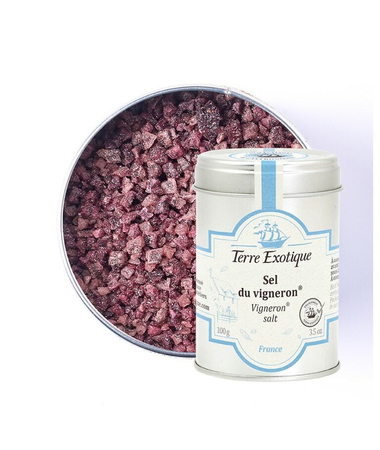 Burk med Terre Exotique Vinodlarsalt (100g). De grova, lila-röda saltkristallerna ligger på en sked bredvid ett glas rött vin, en druvklase och en bit grillat kött på en rustik träplanka.