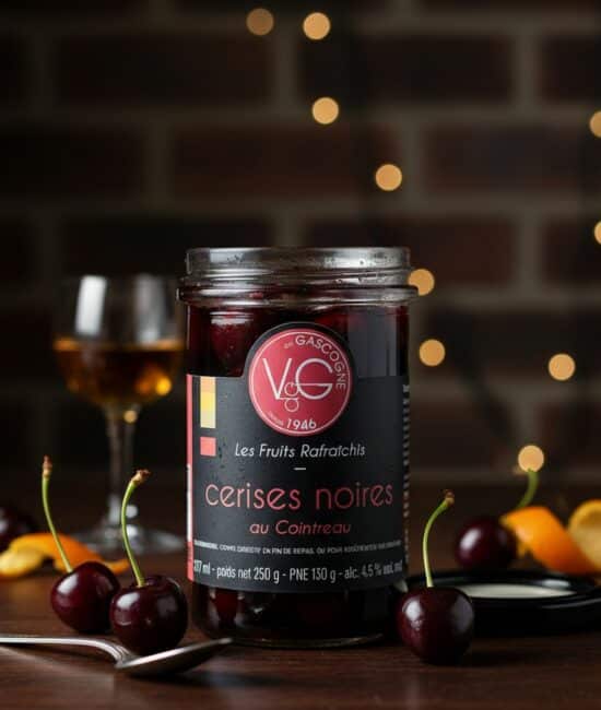 Burk med svarta körsbär i Cointreau, arrangerad med ett glas konjak och färska körsbär mot en mörk bakgrund.